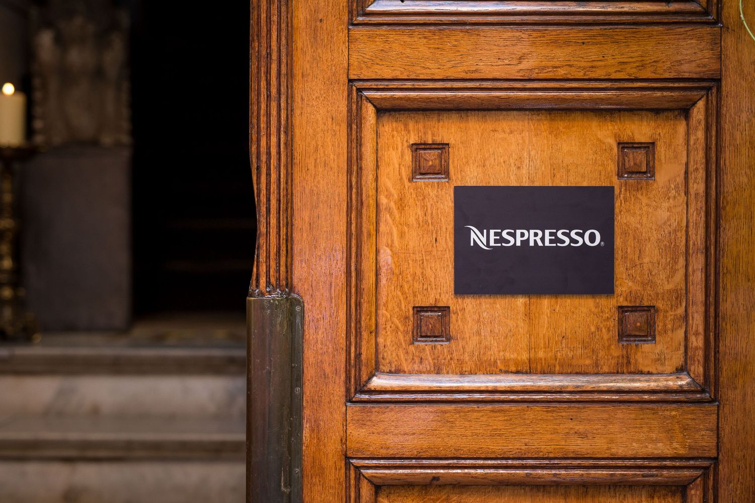 Wooden door with Nespresso logo and classic architectural details.