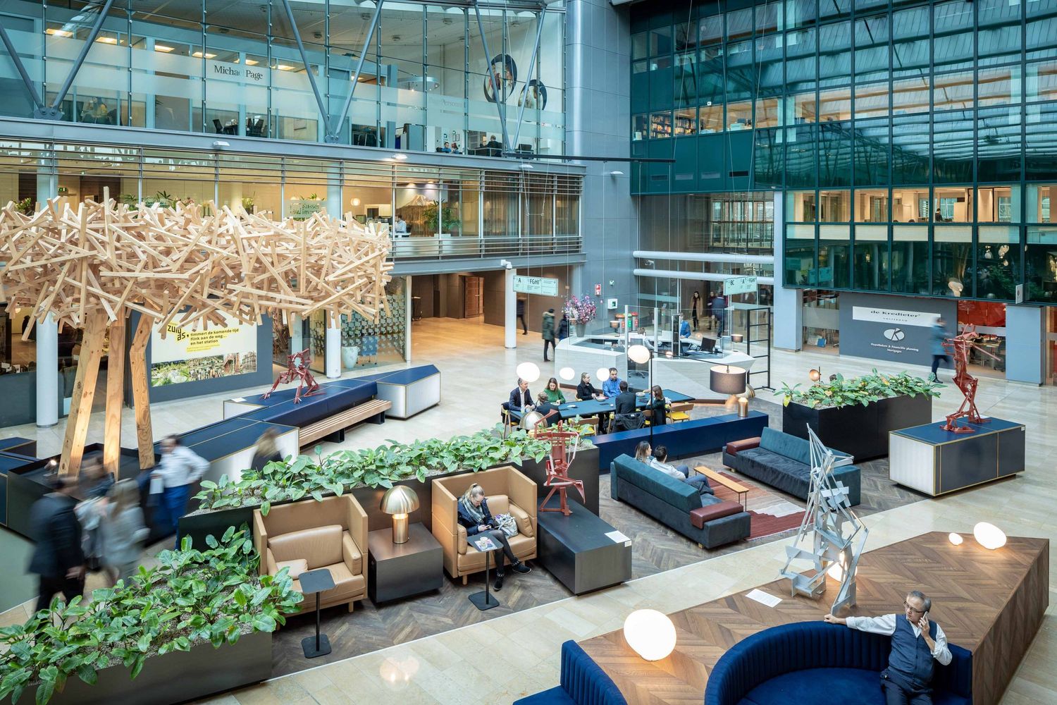 Contemporary workspace interior showcases lounge areas with comfortable seating and indoor plants for a welcoming atmosphere.