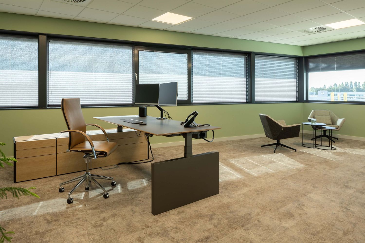 Modern office space with ergonomic chairs, clean desks, and bright fluorescent lighting in an open floor plan layout.