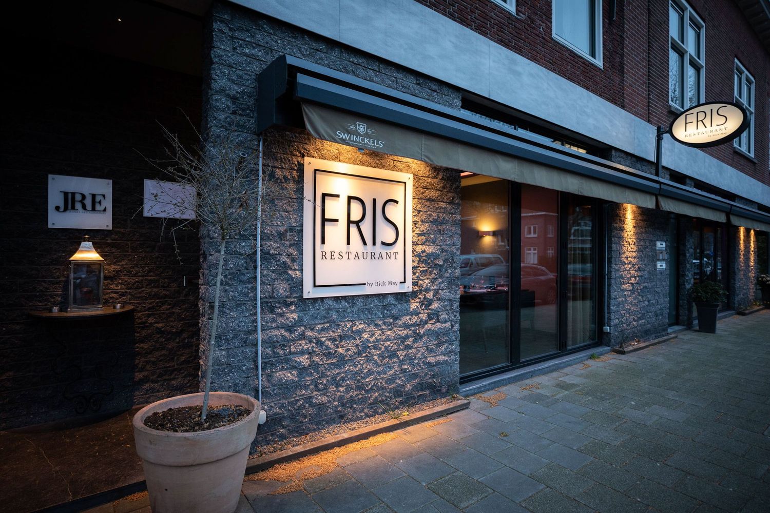 Exterior view of a modern building with stone facade and subtle lighting.