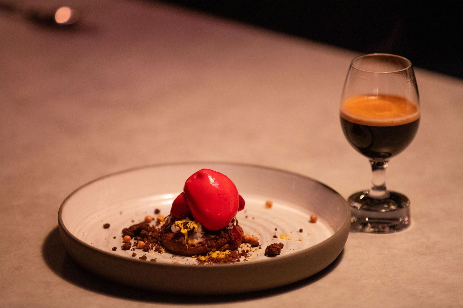 Elegant plated dessert with red garnish on a minimalist white plate.