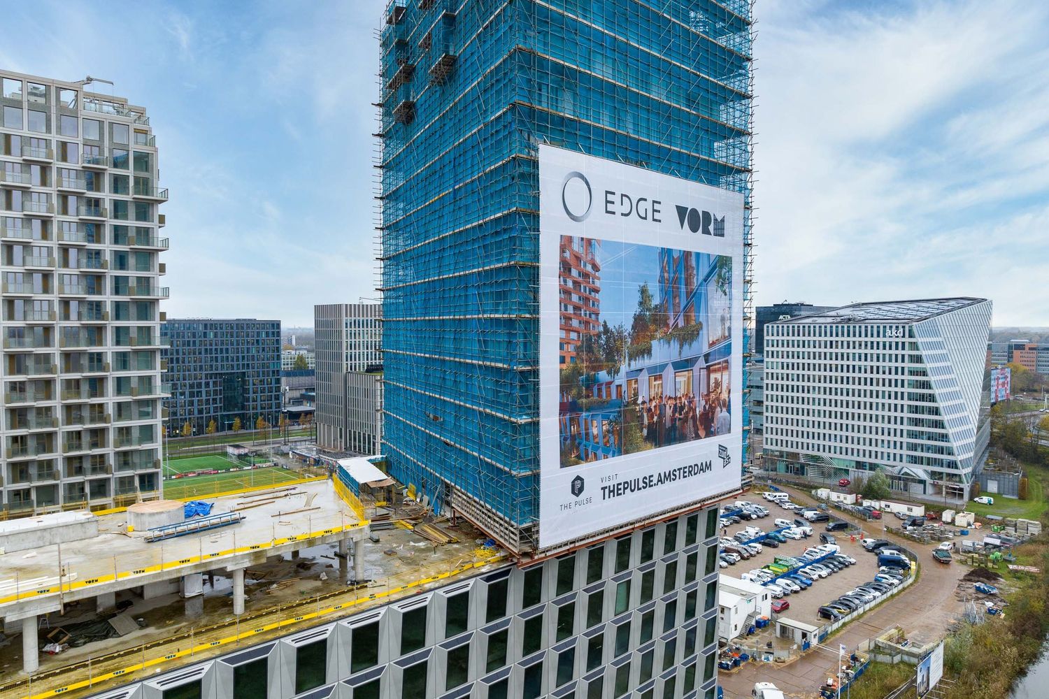EDGE York skyscraper under construction with blue scaffolding in Amsterdam business district.