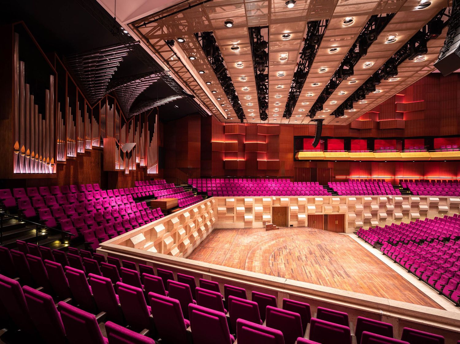 Panoramic collage of a modern concert hall interior showing empty red seats and wooden stage from multiple angles.