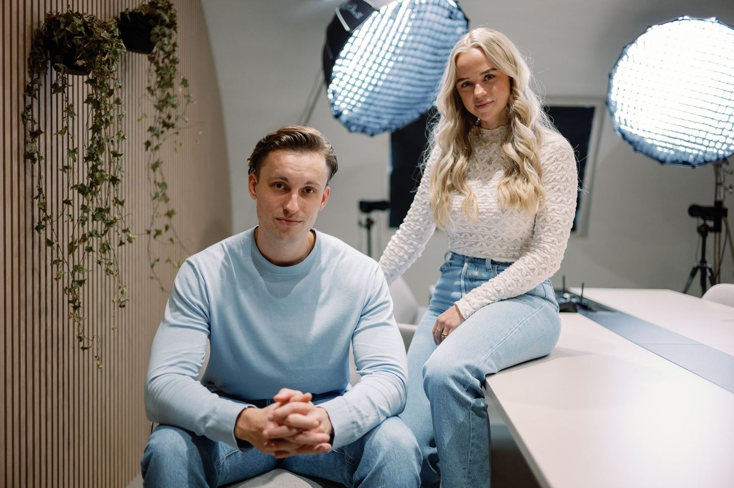 People having a conversation in a podcast studio with blue lighting and recording equipment.