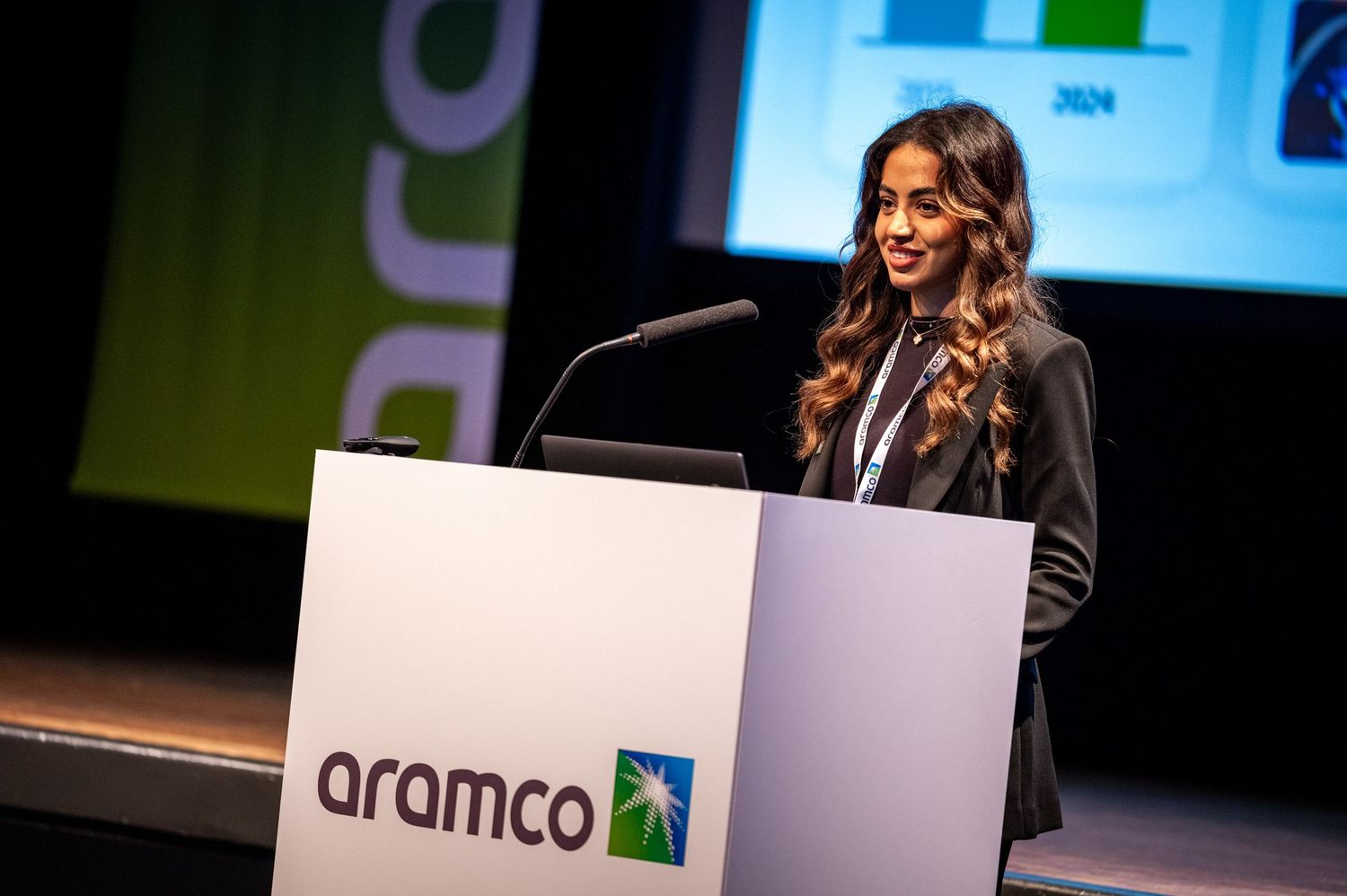 Conference presentation stage with Aramco branding and podium setup.