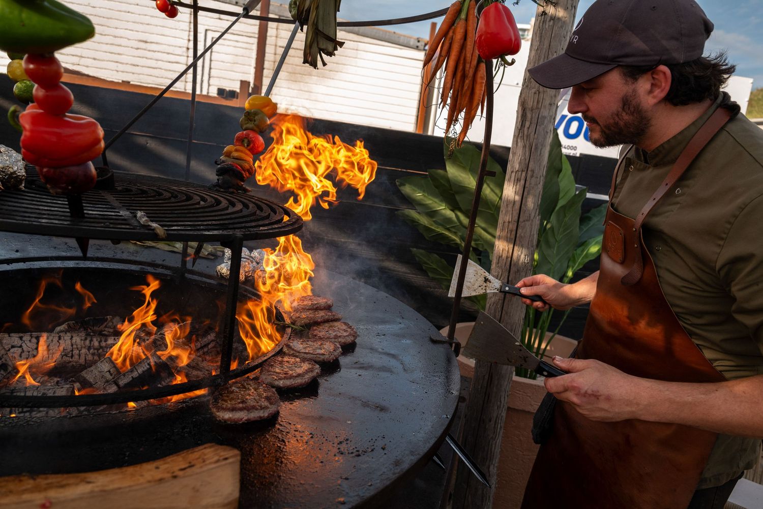 Outdoor cooking station with flames visible during a catered event.