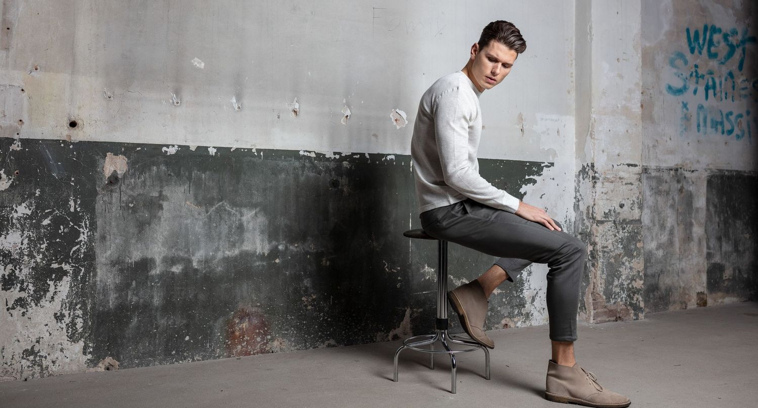 Urban fashion scene with distressed concrete wall and industrial setting.