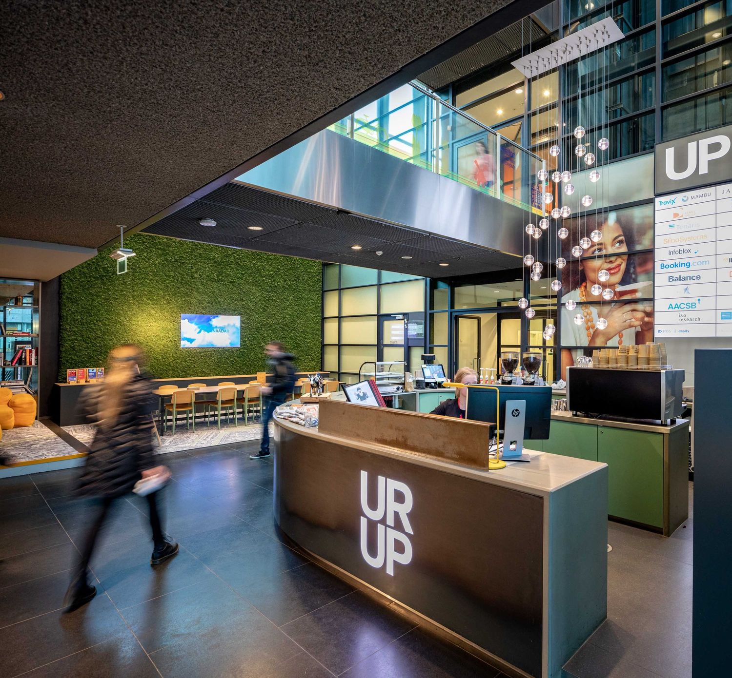Modern office lobby interior with sleek reception desk, green wall accents, and contemporary lighting design.