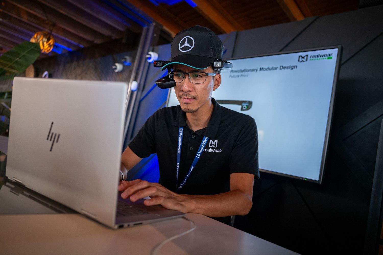 Workspace setup with multiple laptop computers and Mercedes-Benz branding visible.