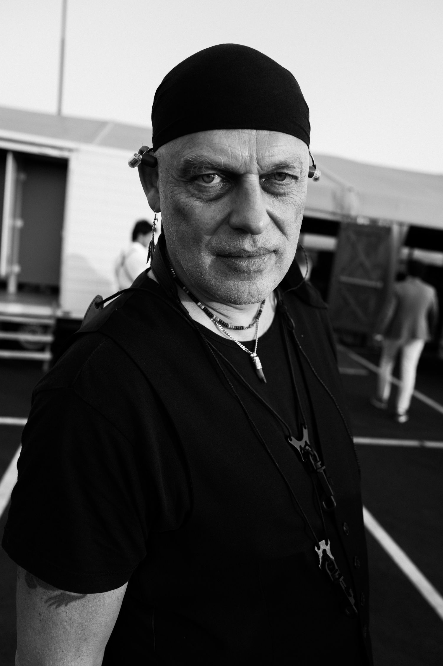 Black and white portrait series showing person wearing black clothing and beanie against light background.