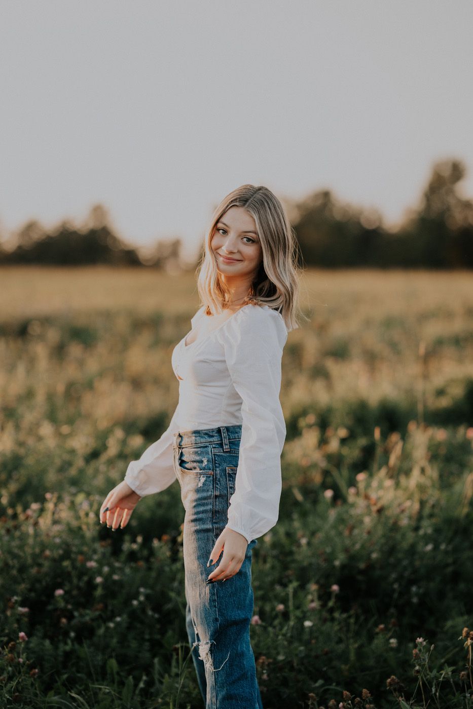 A grad in a flower field during her grad photo session in Woodstock, New Brunswick