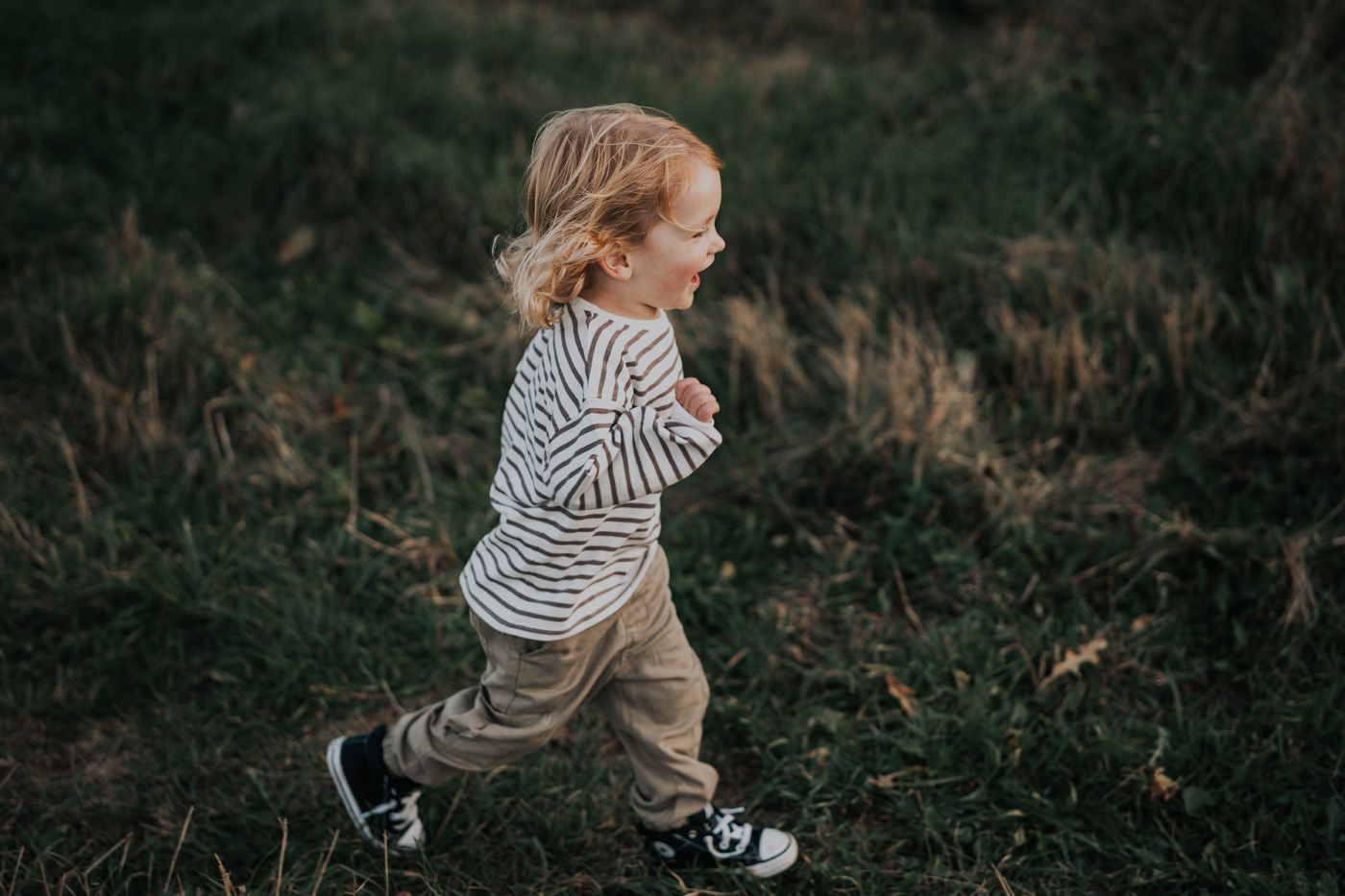 Little boy laughs and runs during family photos in New Brunswick