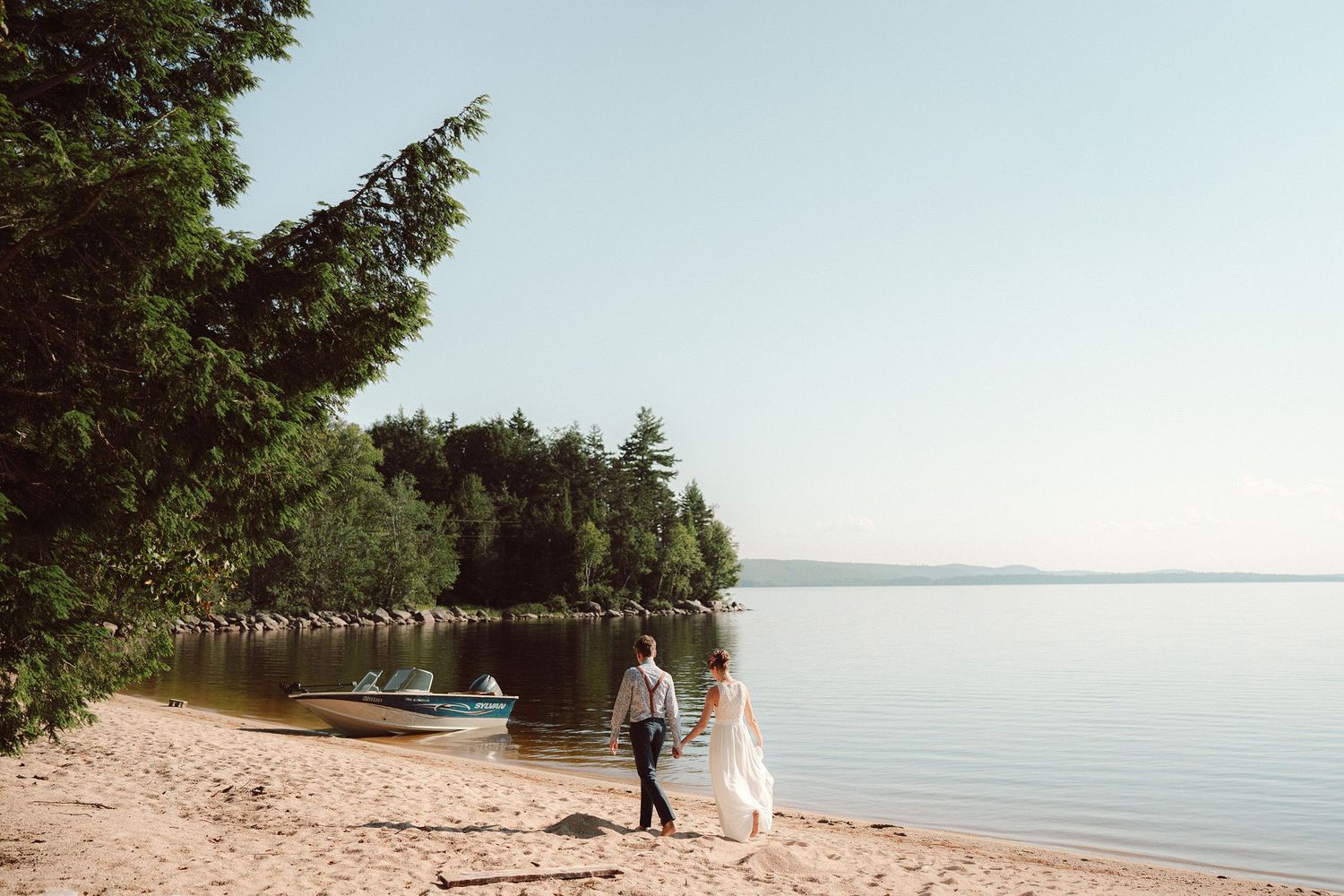 Bride & Groom walking on the beach of Lake Magaguadavic, NB on their wedding day.