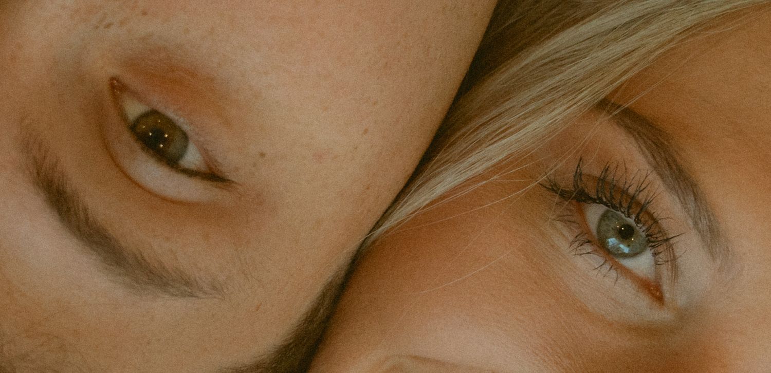 Close-up artistic portrait showing eyes against a neutral background.