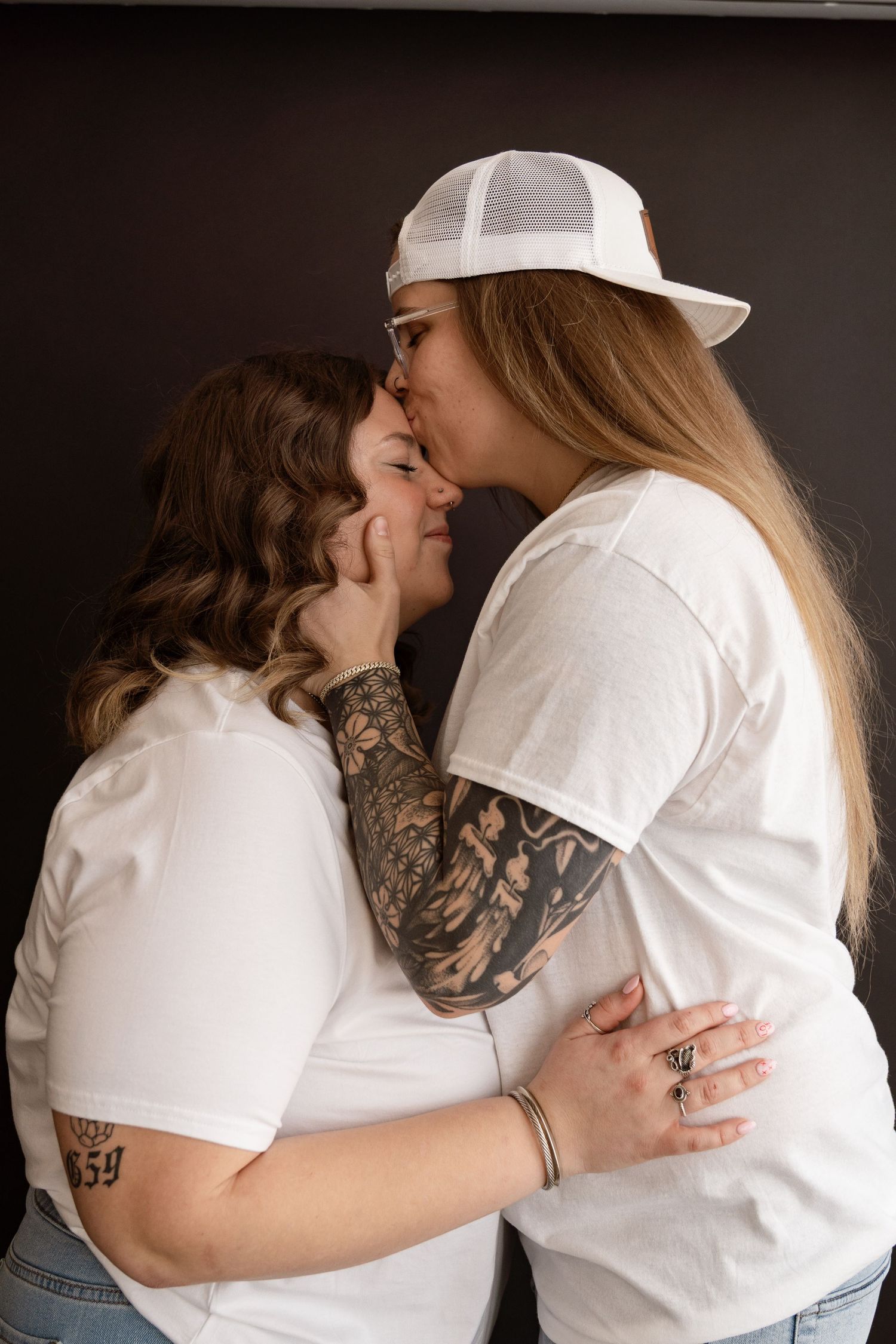 Studio portrait series showing intimate embraces between couple in white shirts.