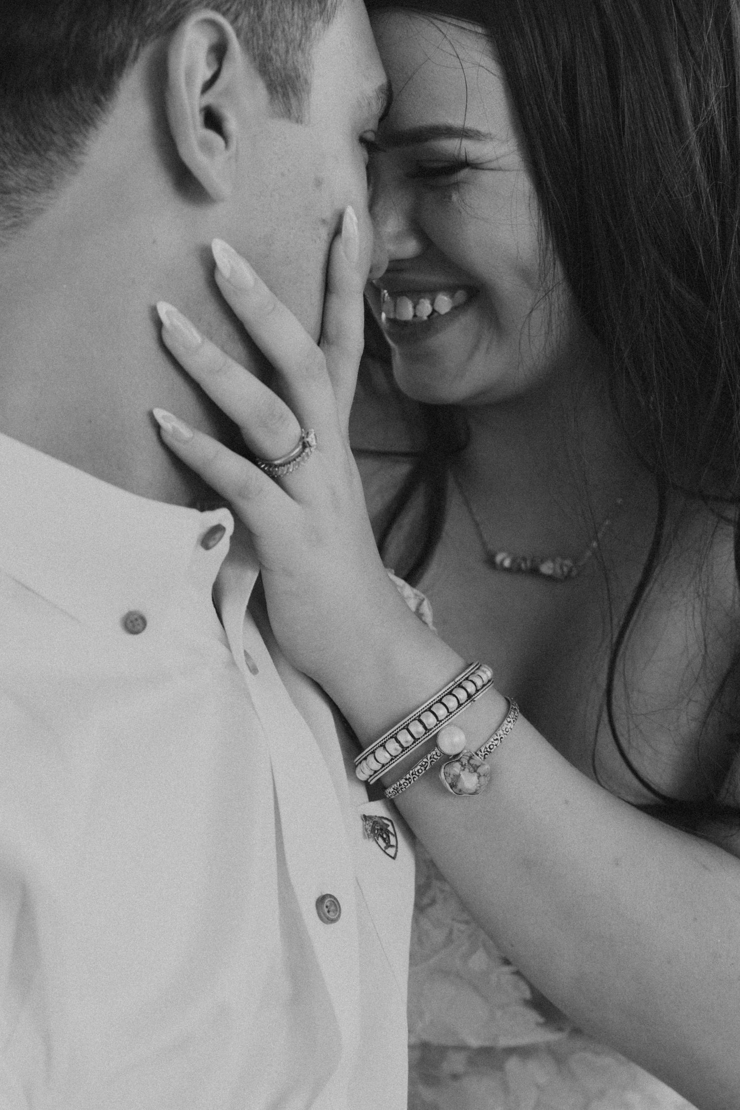 Bride pulls in groom tightly for a kiss with a smile on her face.