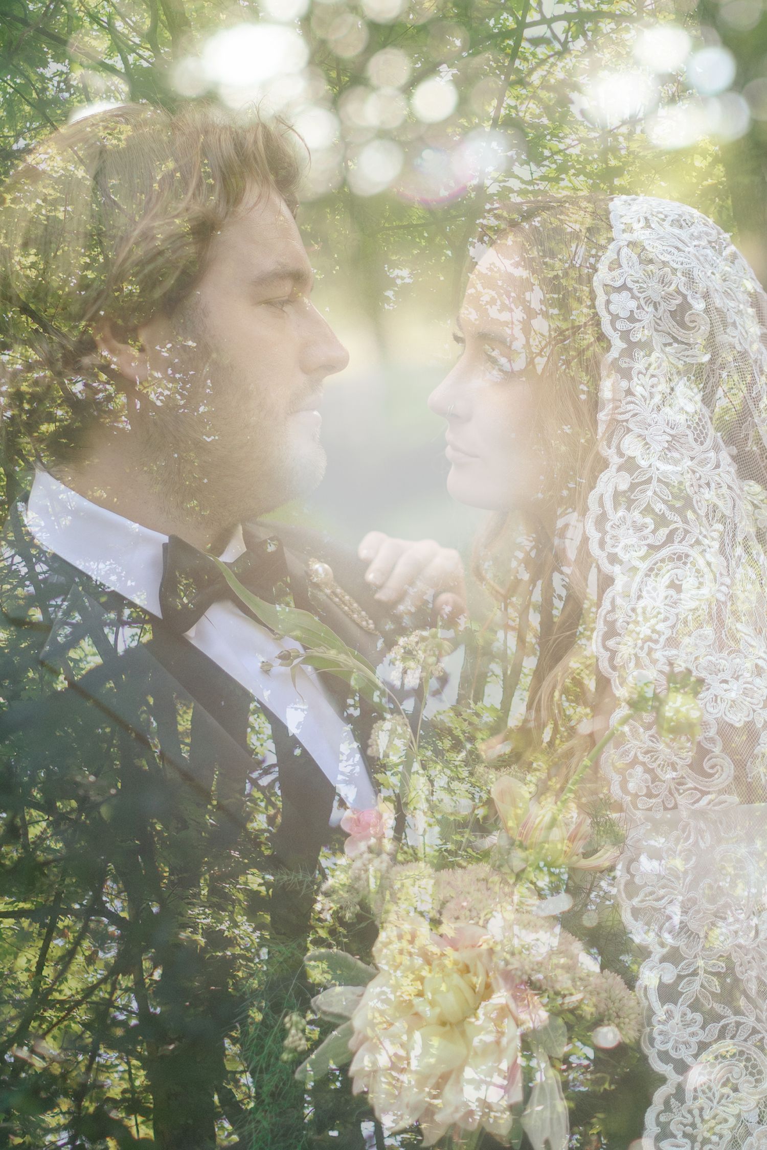 Double exposure wedding photo of bride in lace veil and groom in suit surrounded by lush green trees.