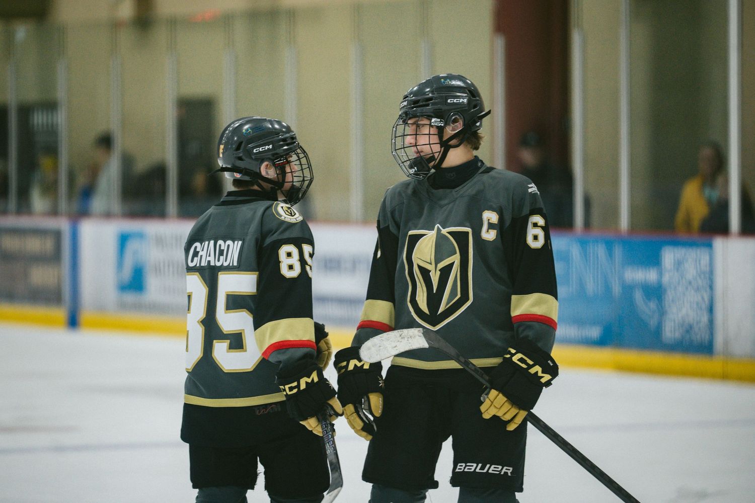 Hockey players in Vegas Golden Knights uniforms position themselves during gameplay.