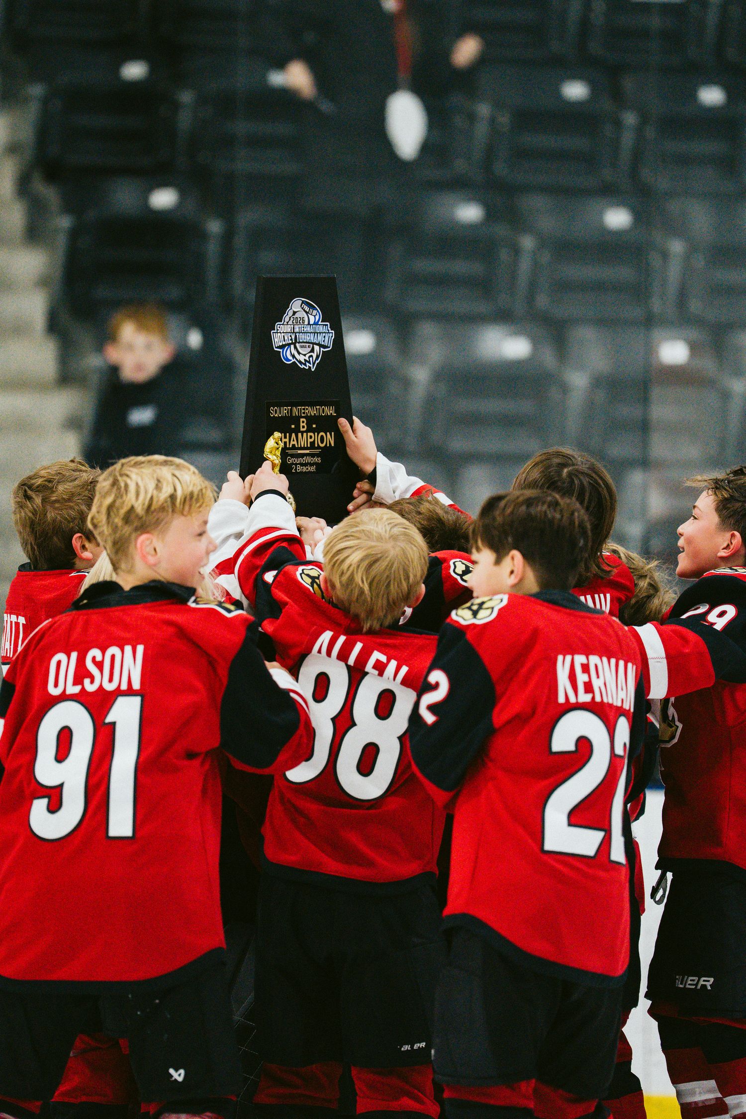 Youth hockey team in red jerseys lined up together showing team spirit and camaraderie on the ice.
