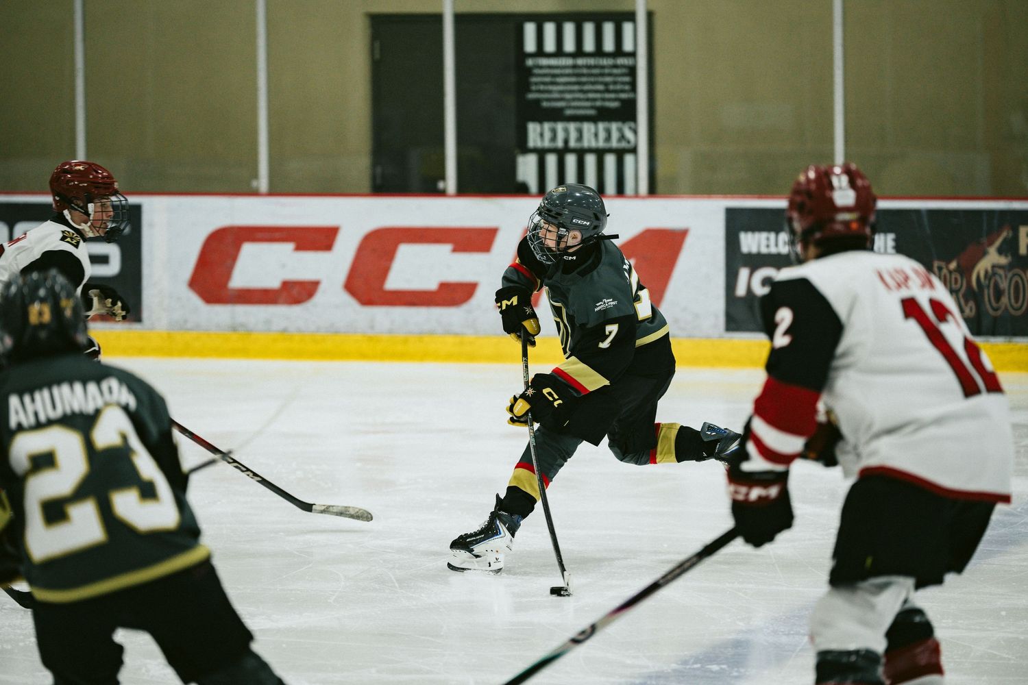 Ice hockey players from opposing teams compete for the puck during an intense game.