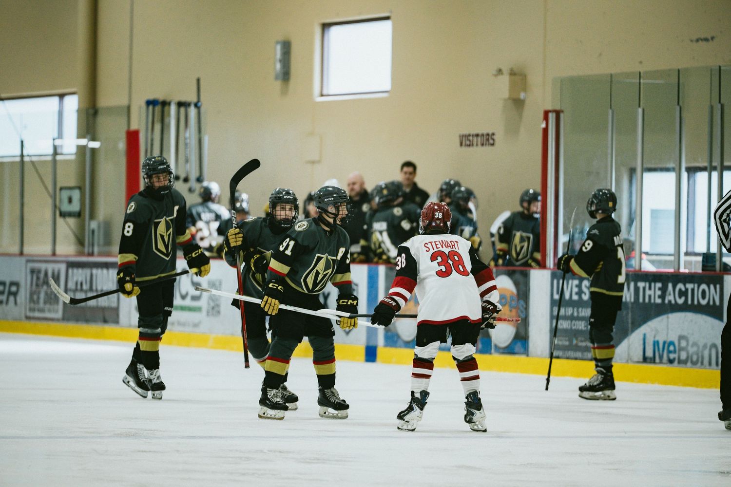 Wide view of hockey players practicing drills on an indoor ice rink.
