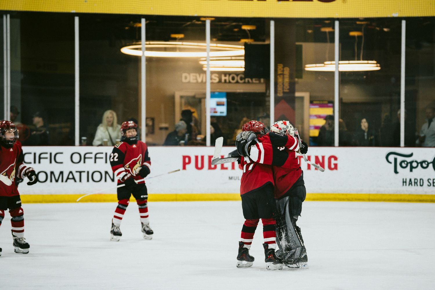 Hockey players spread out on the ice rink during a game or practice session.