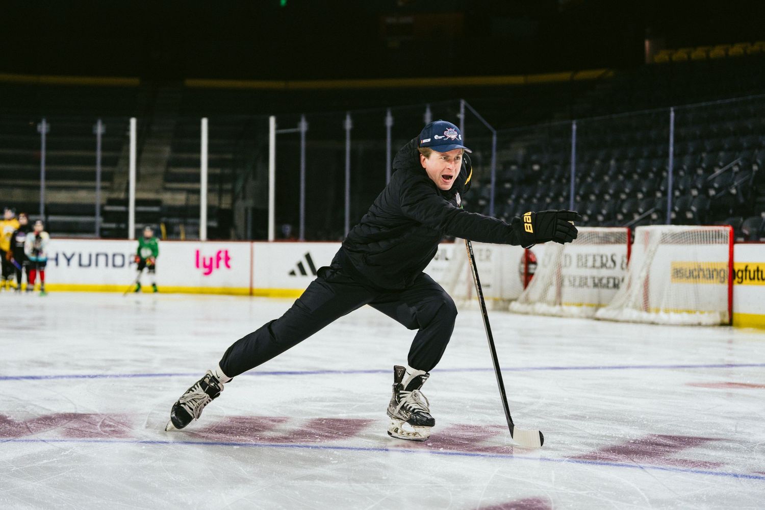 A hockey player practices skating technique on an indoor ice rink during a training session.