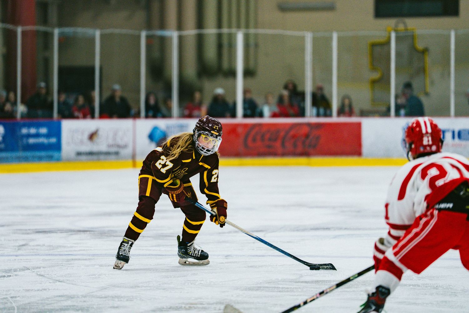 Hockey players from opposing teams battle for puck control during fast-paced game on ice.