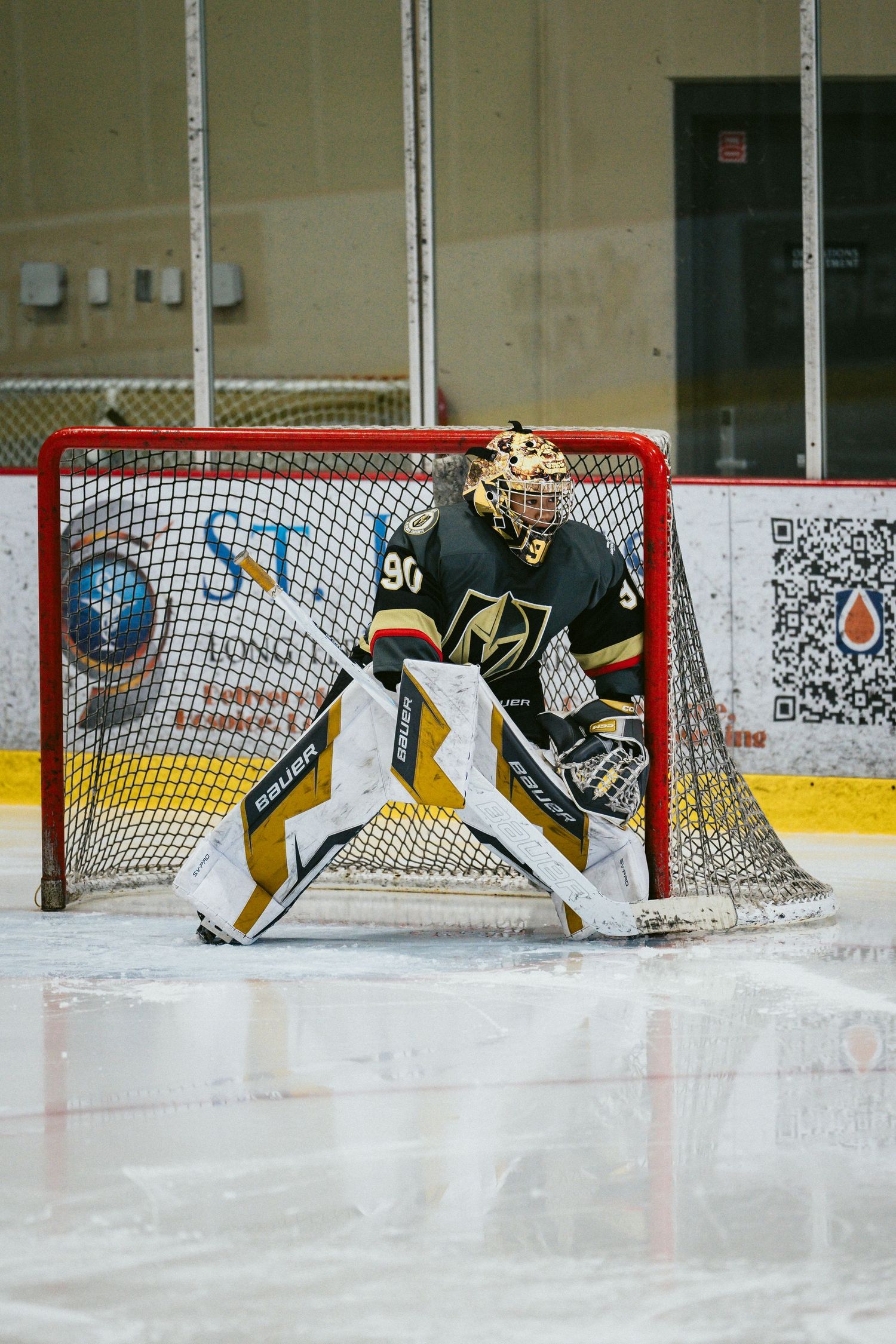 Goalie in Vegas Golden Knights uniform defends the net during an ice hockey match.