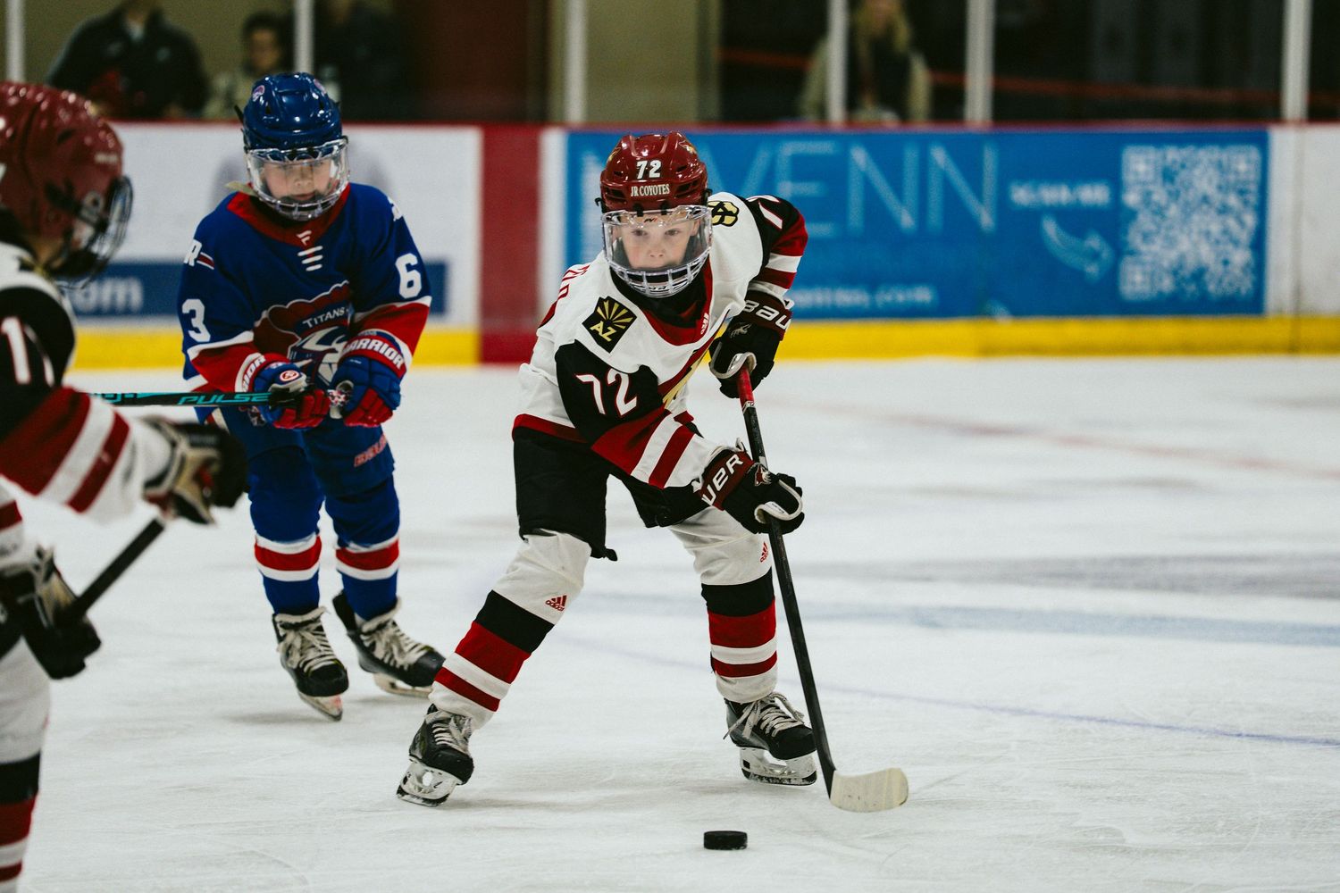 Hockey players from opposing teams compete for the puck during an ice hockey match.