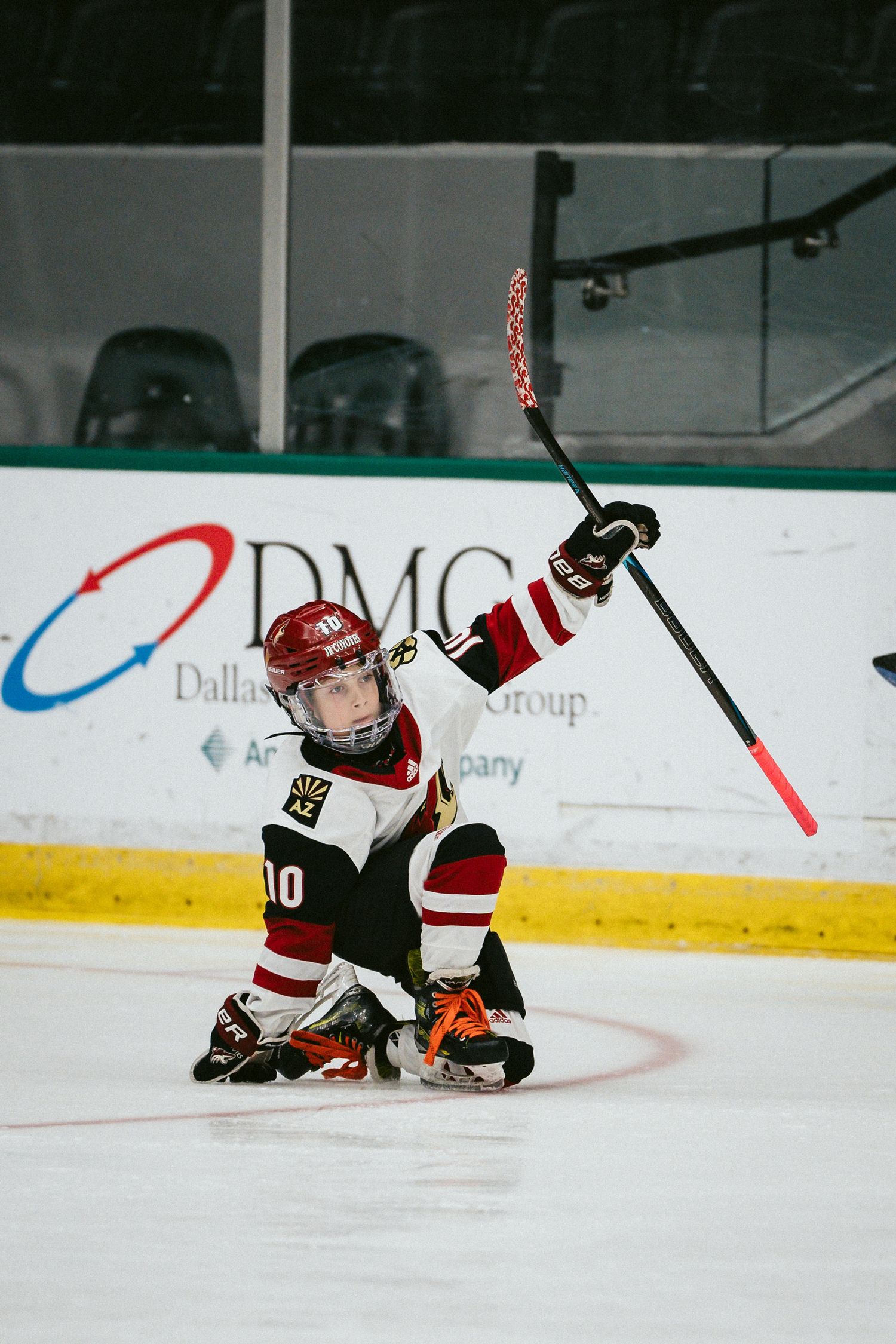 Hockey players dive and stretch on ice during competitive game play.