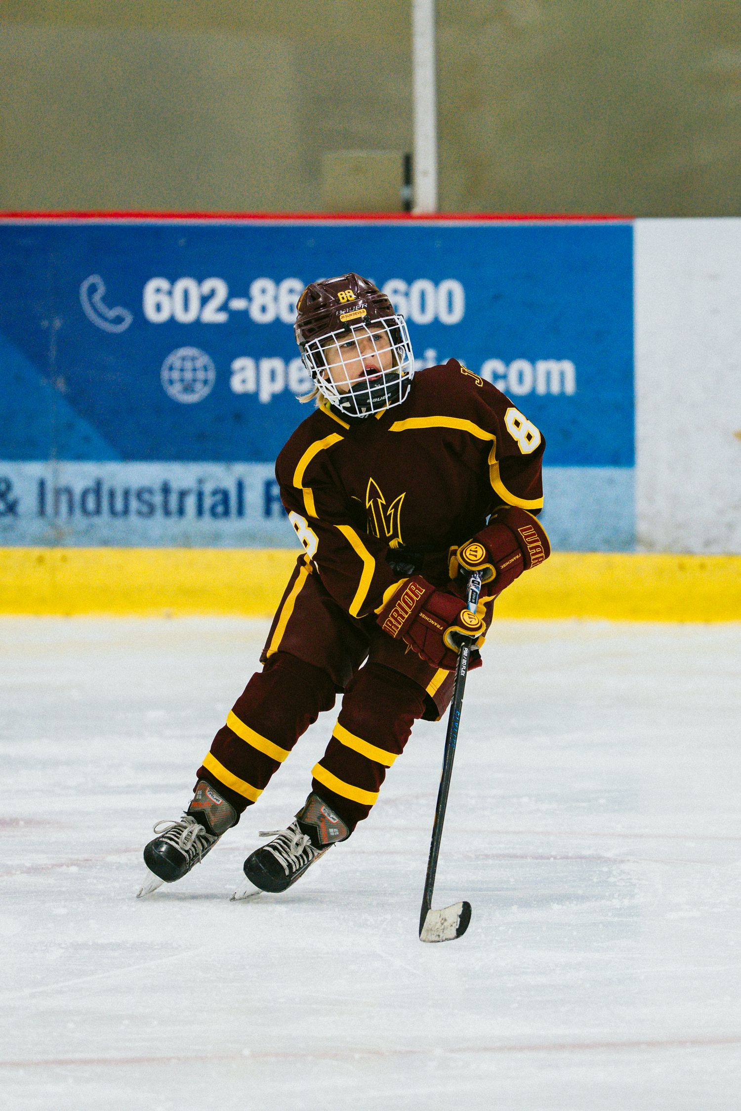 Hockey players in black and gold uniforms skating in formation during a game.