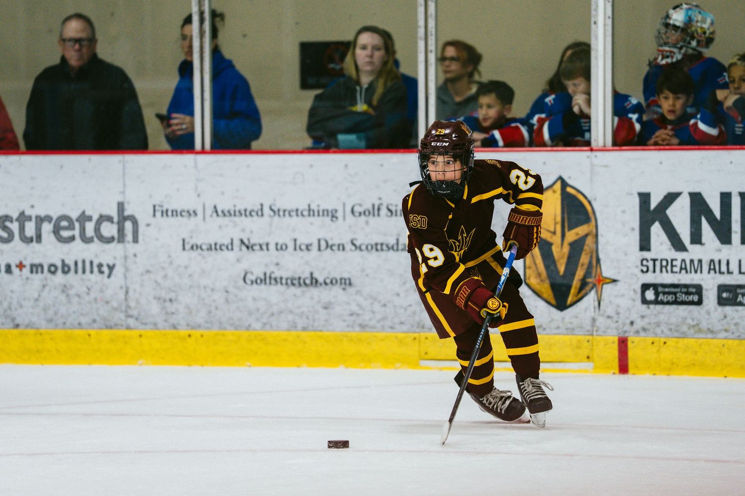 Hockey players from opposing teams battle for the puck during an intense ice hockey match.