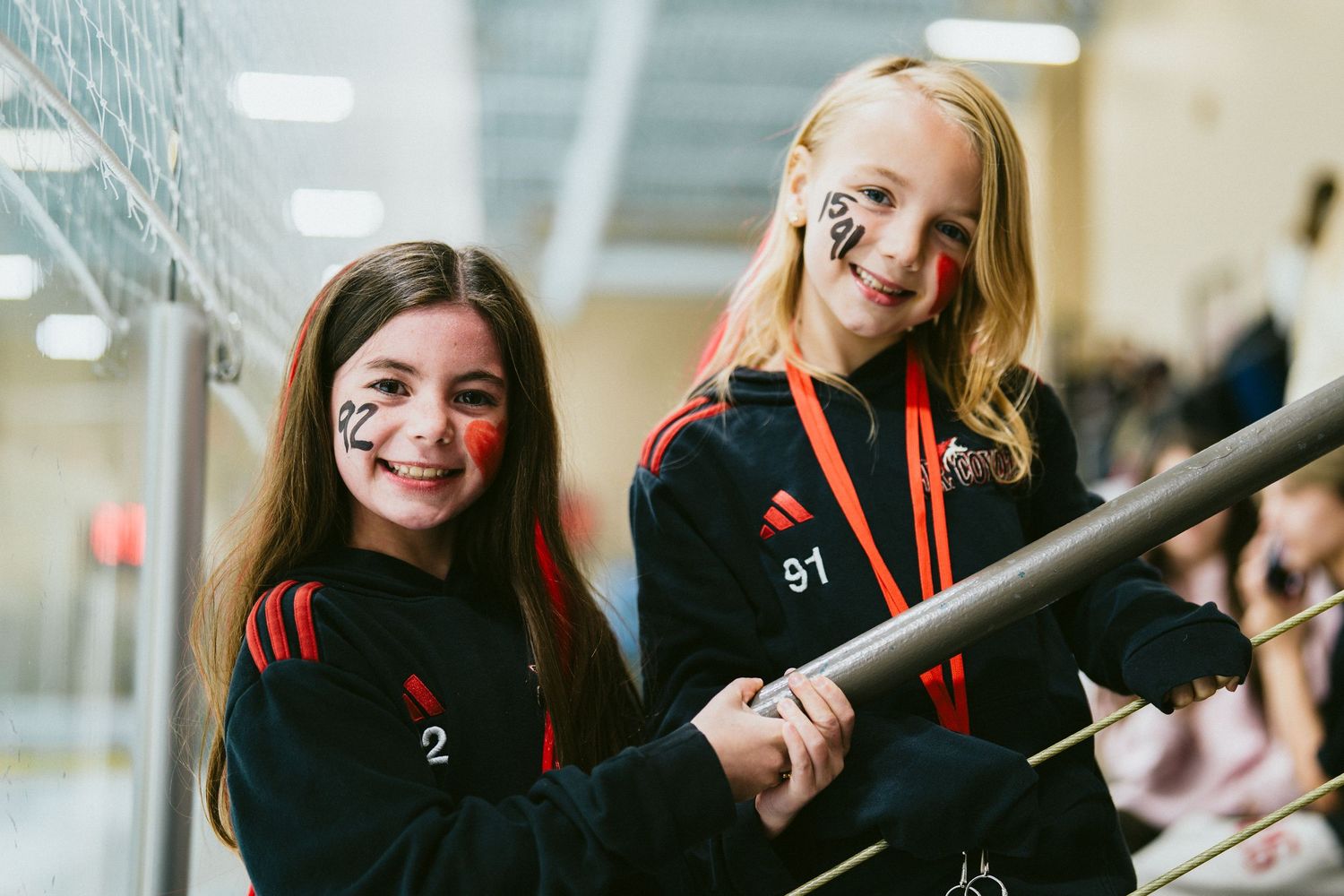 Students in black and red school uniforms pose together in a hallway.