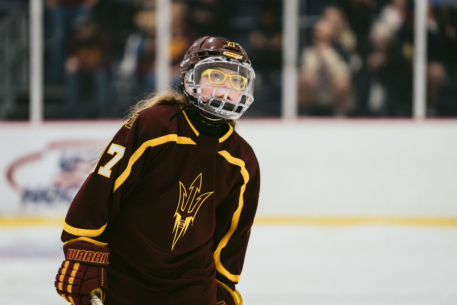 Arizona State Sun Devils hockey player #7 in maroon jersey skating on ice during a college hockey game.