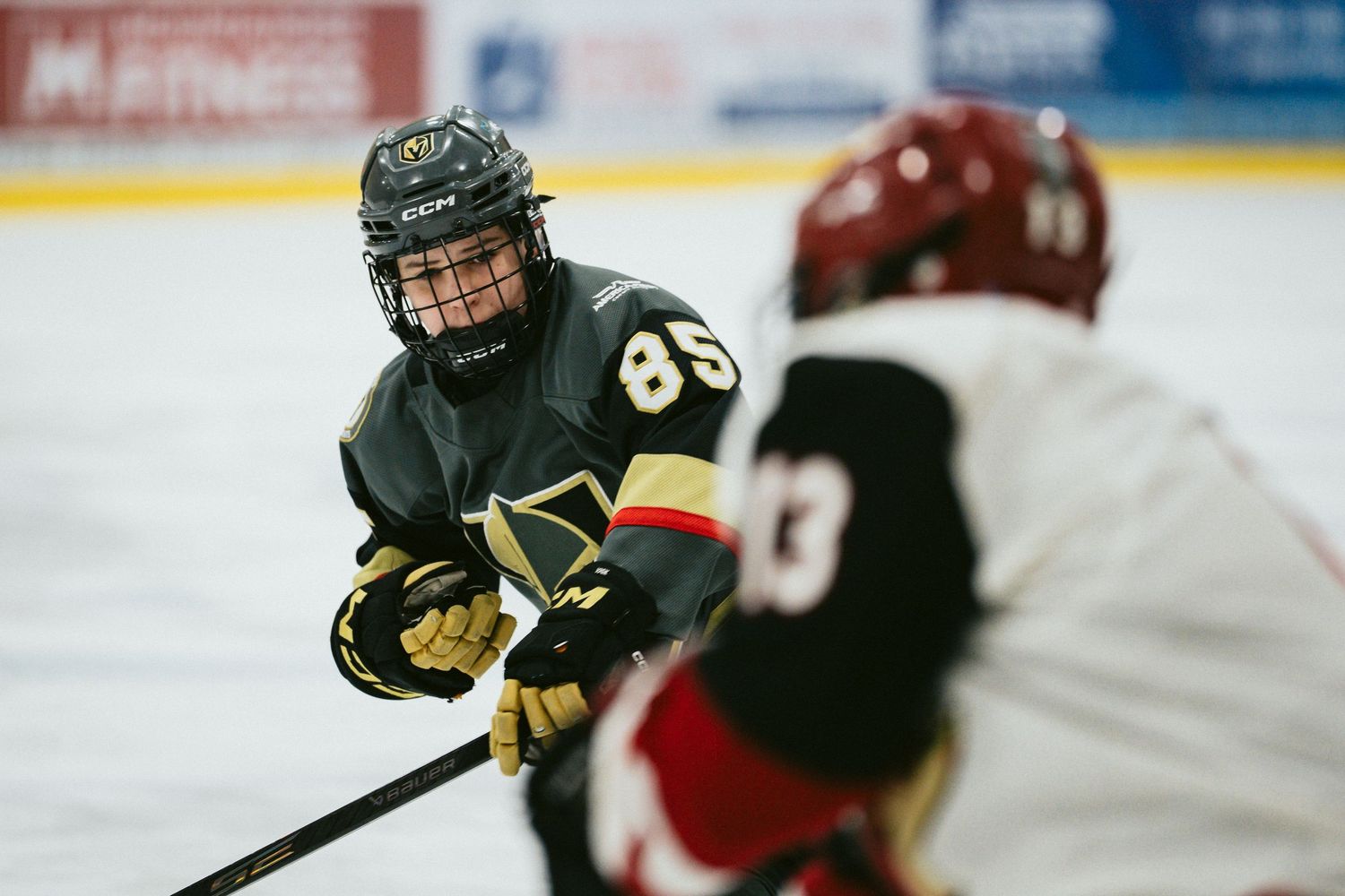 Hockey players from opposing teams compete for control during an intense game moment.
