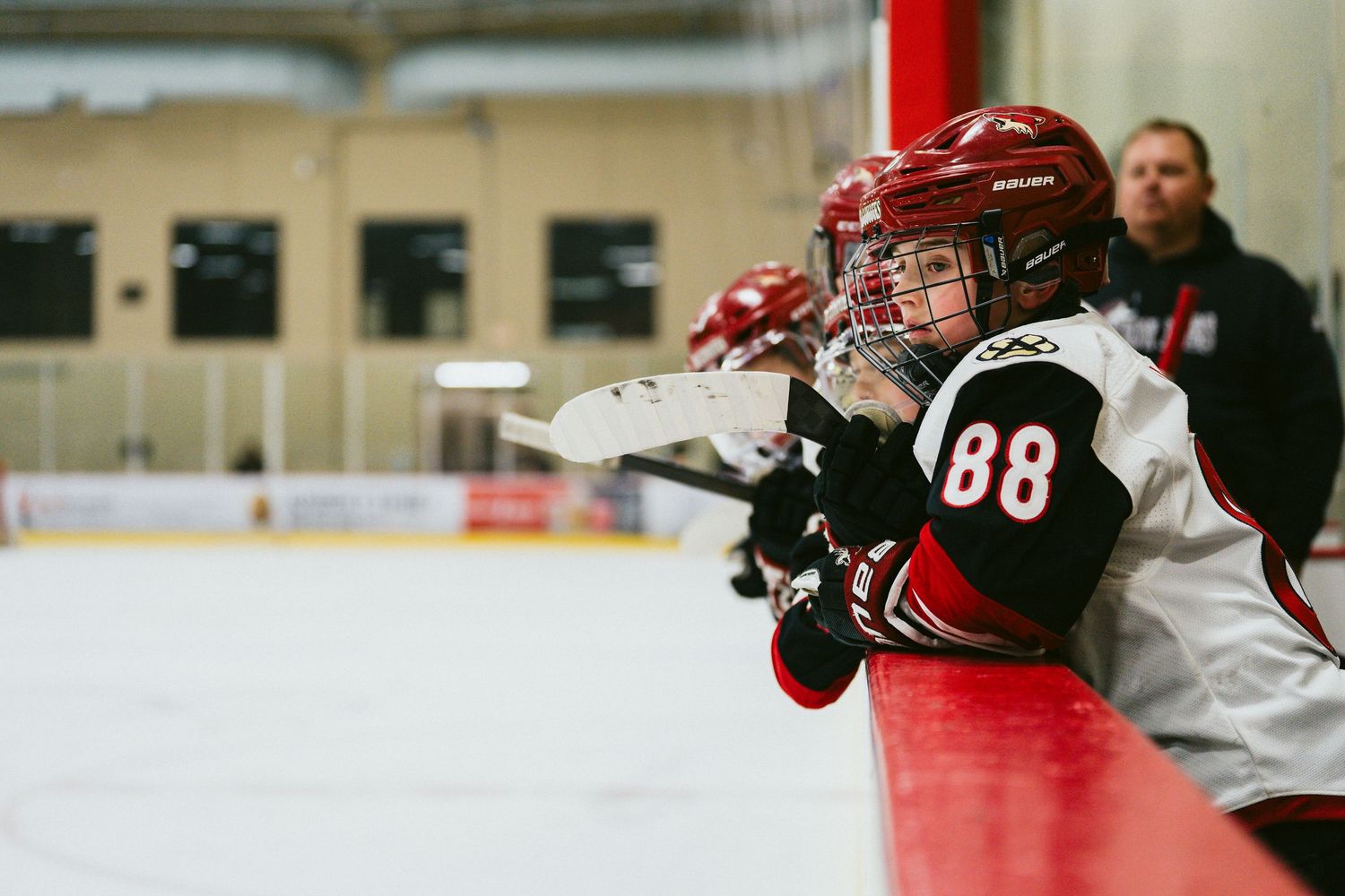 Hockey players in red and white uniforms compete for the puck during an intense game moment.