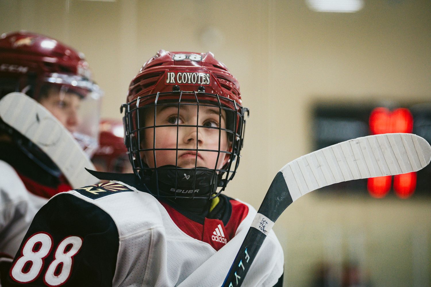Hockey players in red and white uniforms compete during intense game action.
