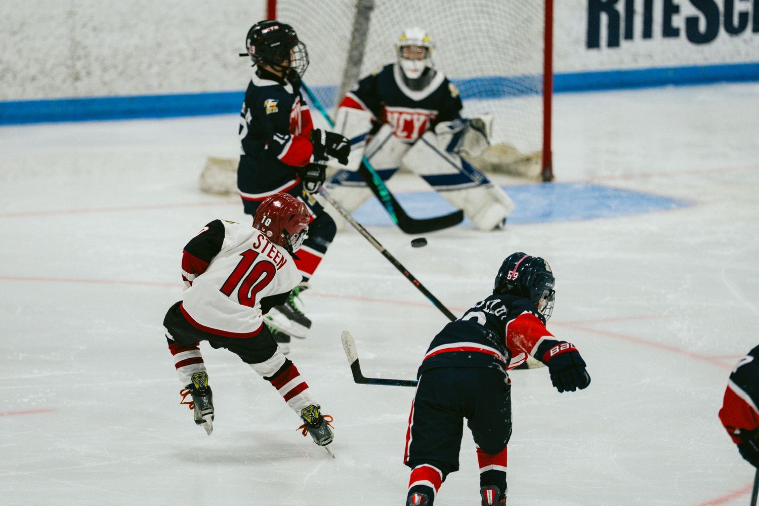 Wide view of hockey players practicing on indoor ice rink.