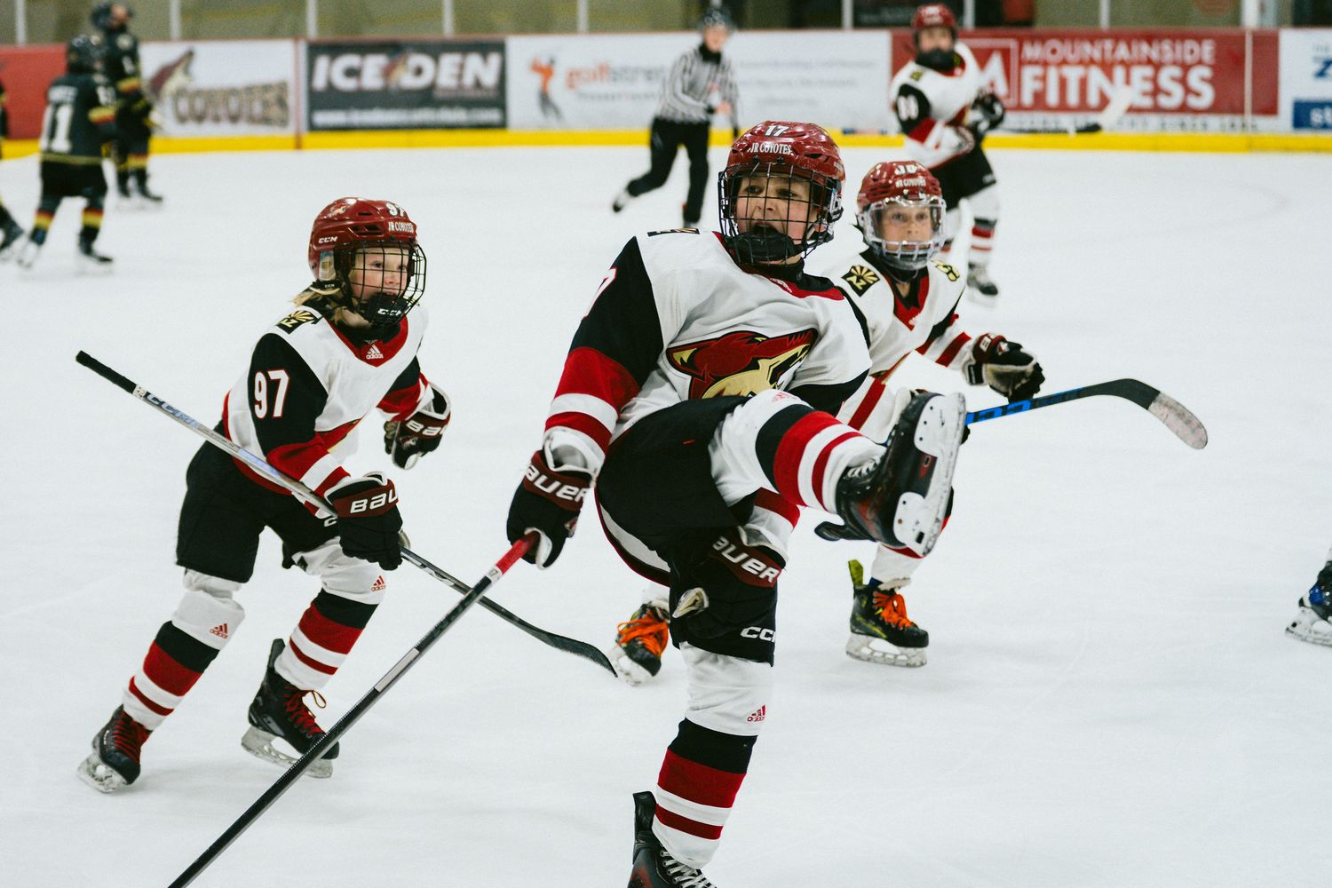Hockey players in red and black uniforms spread across the ice during gameplay.