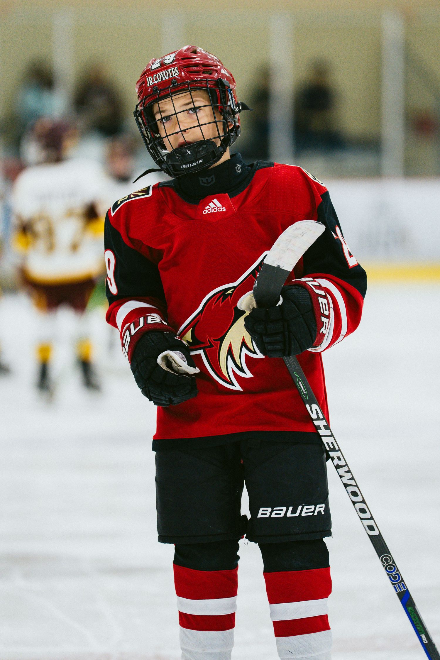 Youth hockey players in red jerseys practicing on ice rink during training session.
