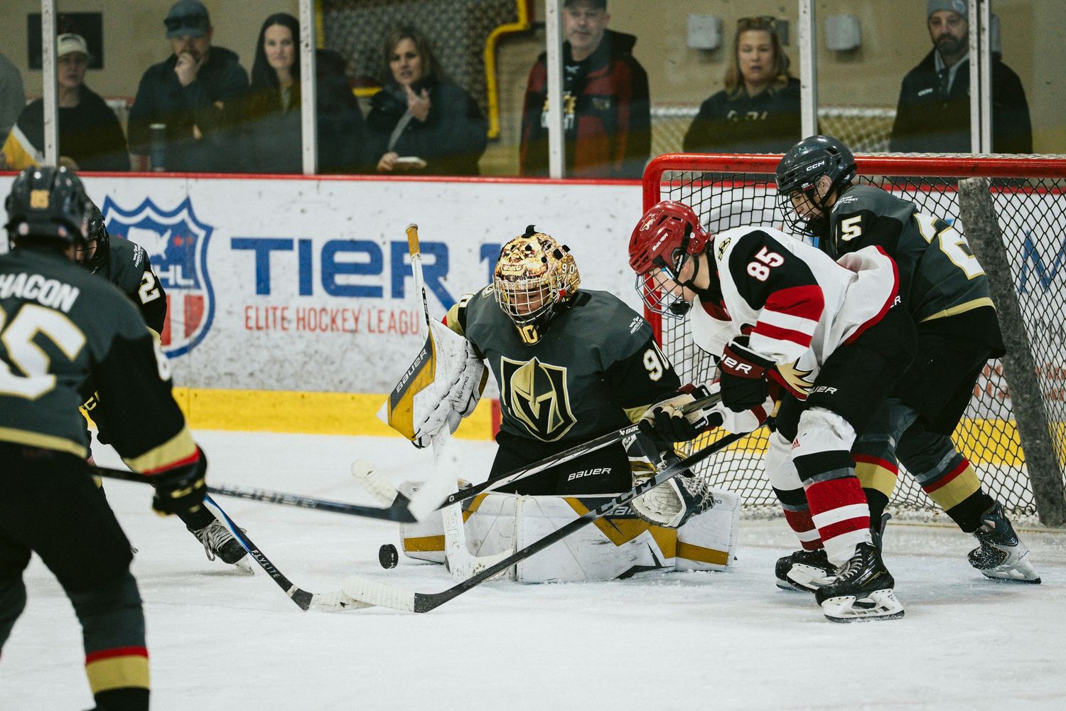 Intense hockey action near the goal with players battling for puck control.