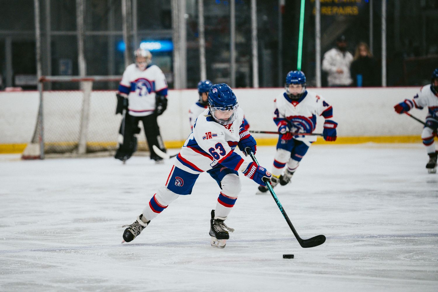 Ice hockey players battling for puck control during competitive match.