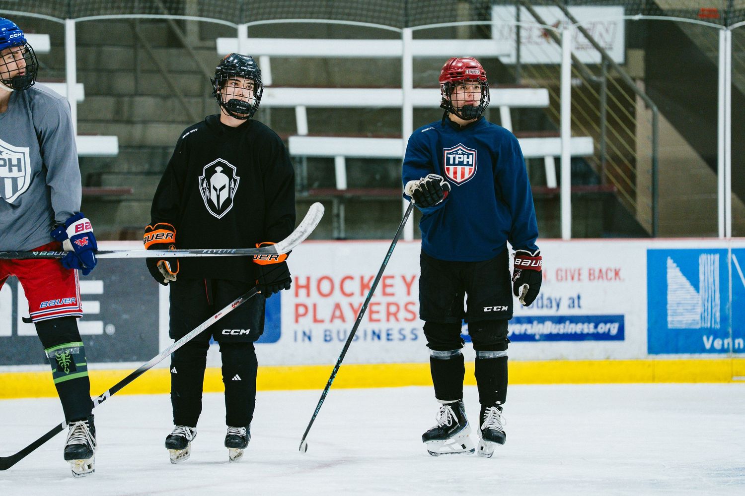 Two youth hockey players in dark jerseys stand on the ice during a TPH hockey training session.