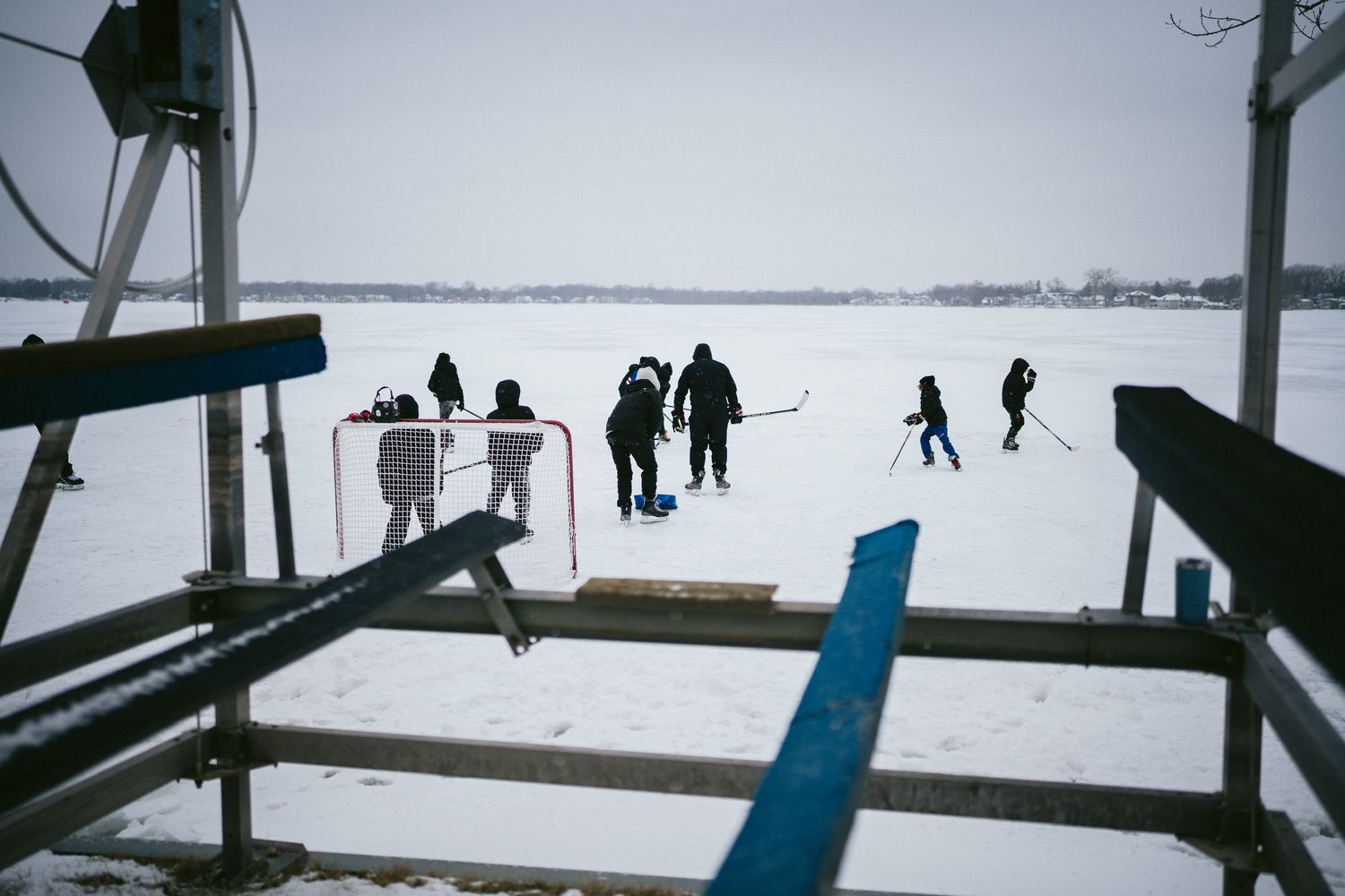 Winter landscape with silhouettes of people walking on frozen lake.