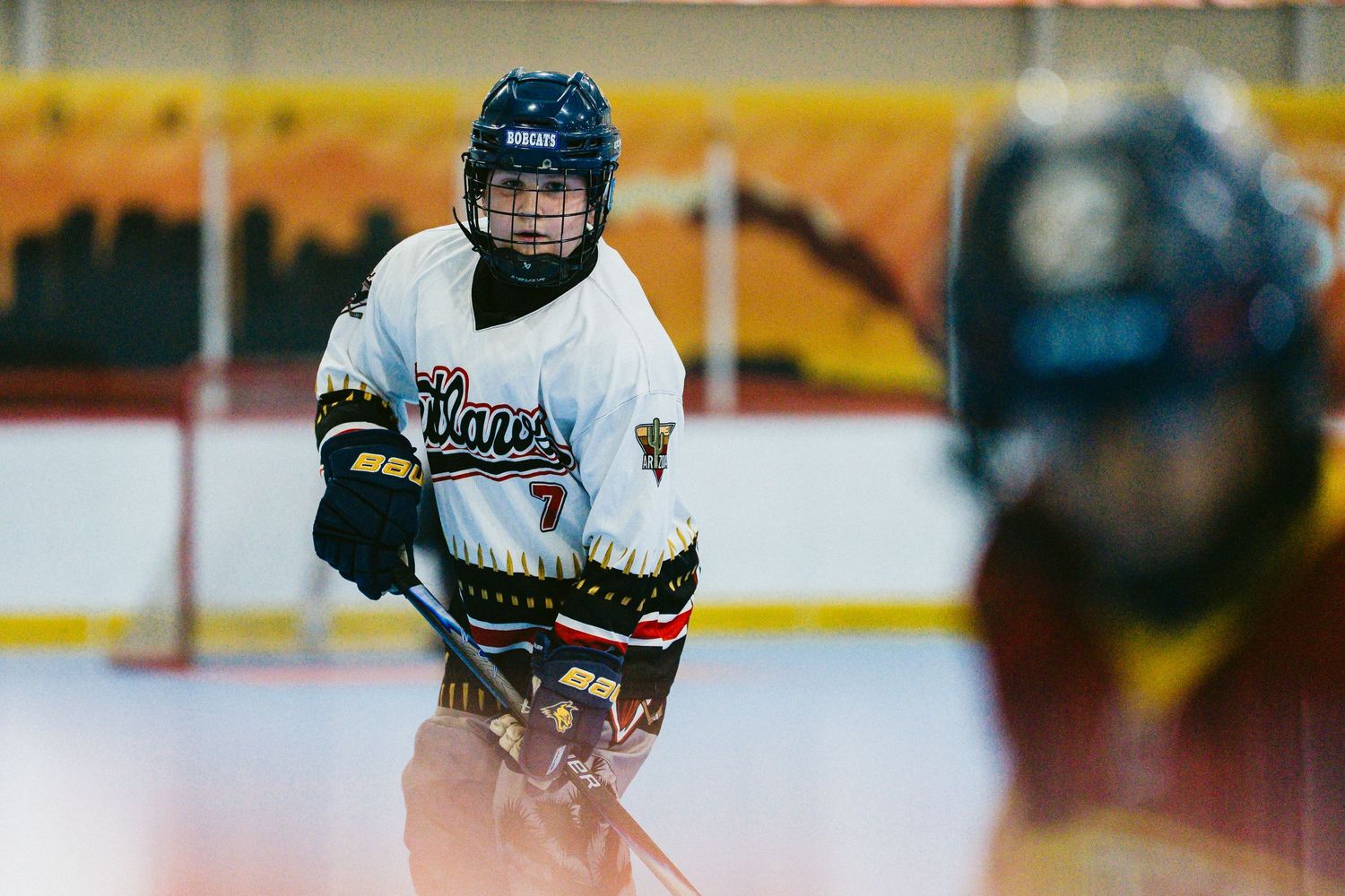 Youth roller hockey player wearing number 7 Claws jersey focuses during an indoor rink game.