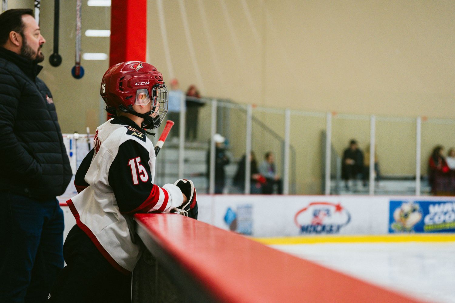 Hockey players in red and white jerseys battle for position during a competitive match on the ice.