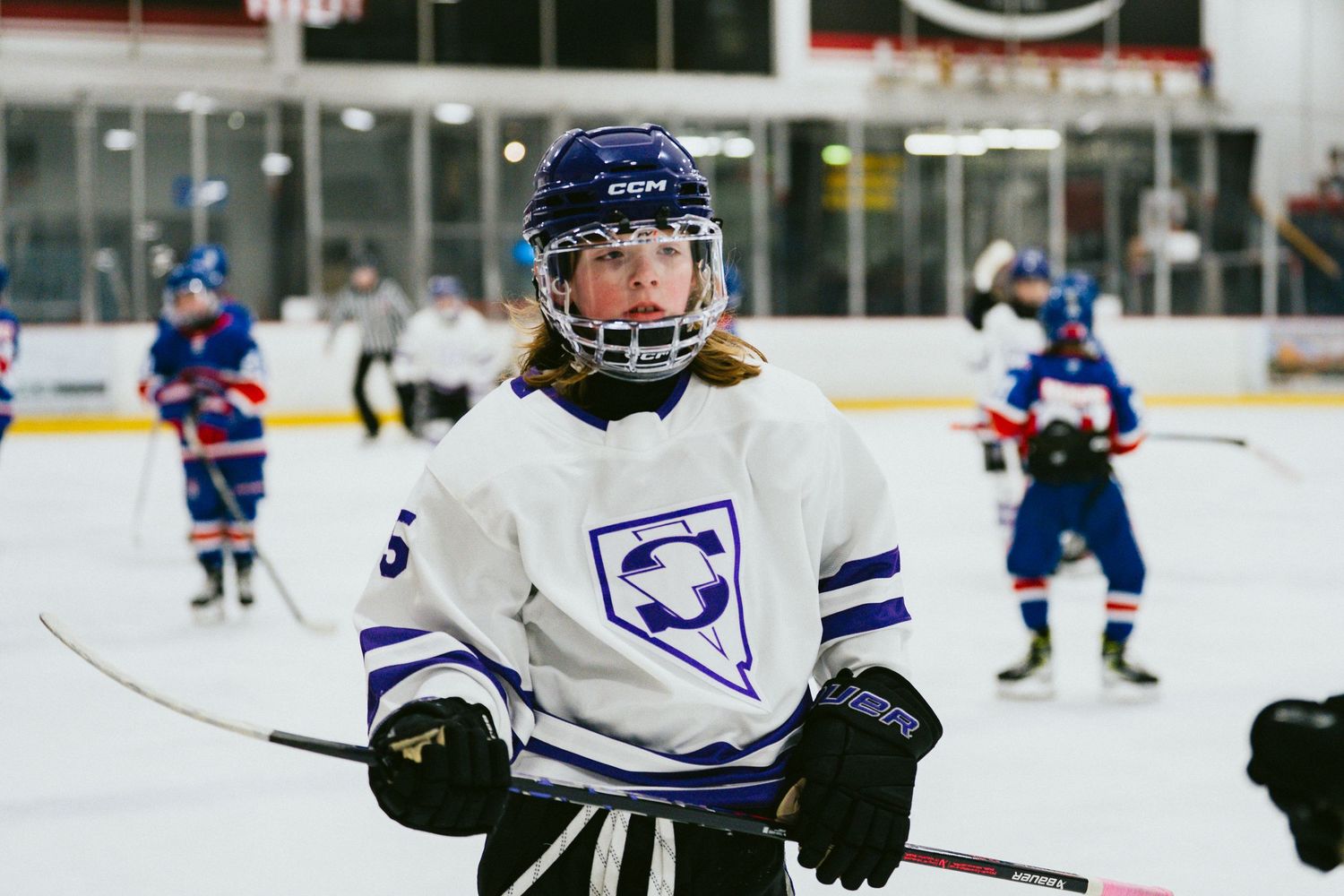 Hockey player in white jersey making a play with the puck during an ice hockey match.