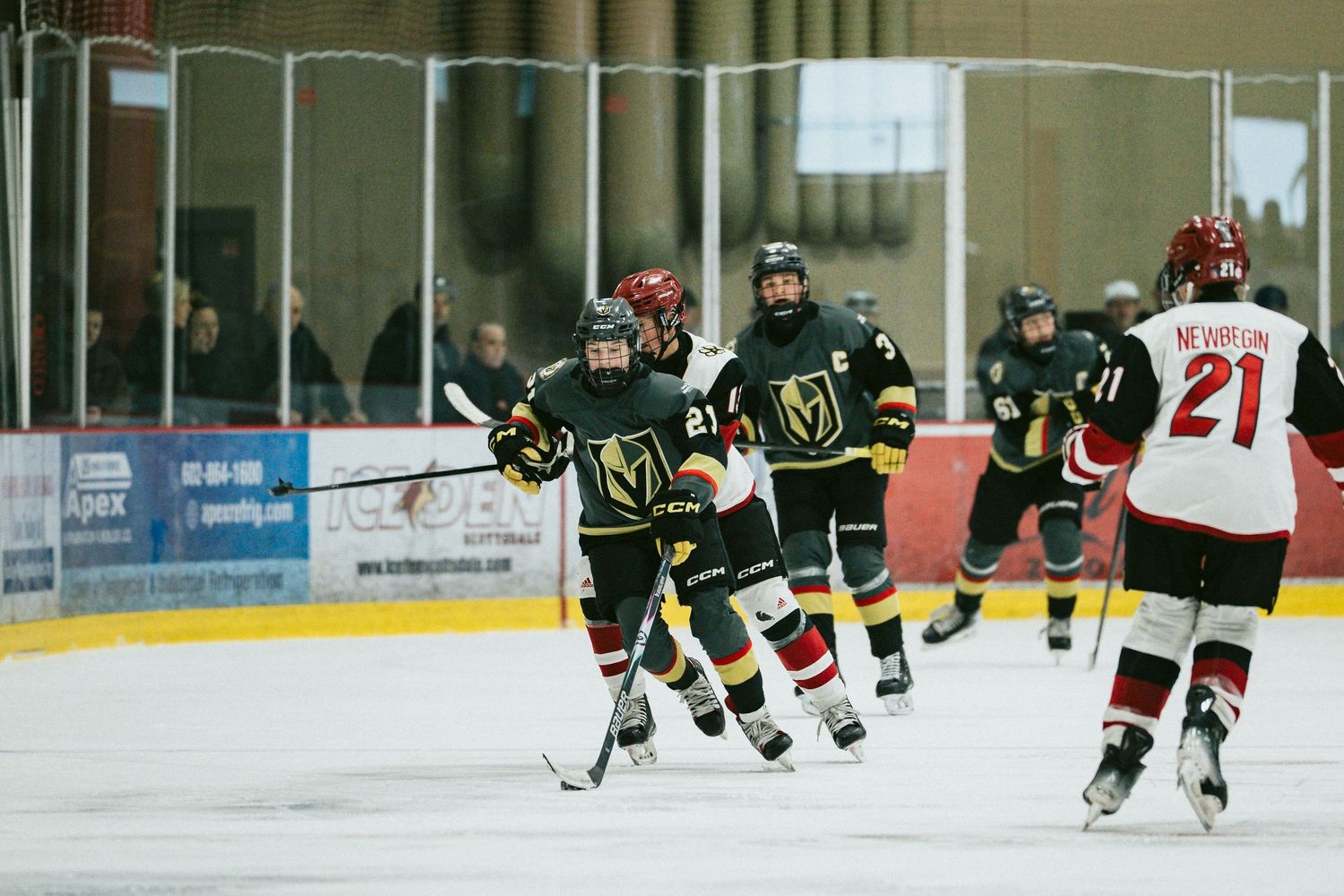 Hockey players from opposing teams skating during competitive game action.