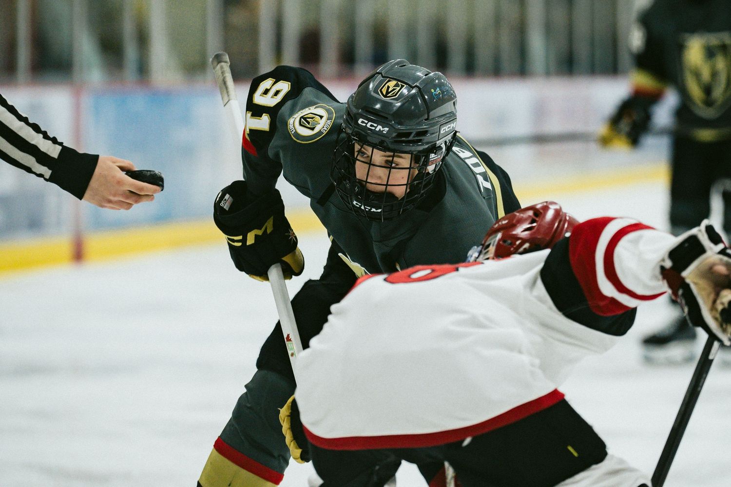 Two hockey players collide during physical play along the boards.